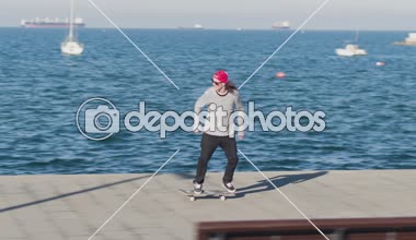 Yakın: güneşli okyanus arka planda ile seyir yapmak 360 flip hüner, genç profesyonel kaykaycı. Kaykay ve sahil boyunca deniz kenarında çarpıcı yaz gününde atlama patenci