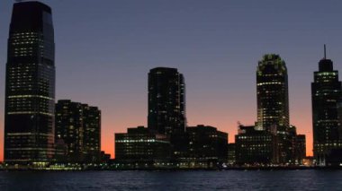 Yakın: içinde parlayan sihirli şehir ışıkları gece tarafından Jersey şehri yaktı. New Jersey manzarası ile ünlü Goldman Sachs Kulesi, konut ve waterfront condominiums altın ayarı gökyüzü karşı