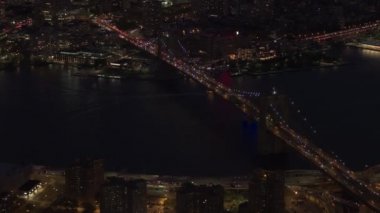 Hava Heli Shot, hayır görünür ticari markalar: ikonik Brooklyn Köprüsü üzerinde hareket otomobil trafik ışıkları ile büyülü yaz gecesi New York'ta aydınlandı. Meşgul karayolu ve sokaklarda yoğun trafik