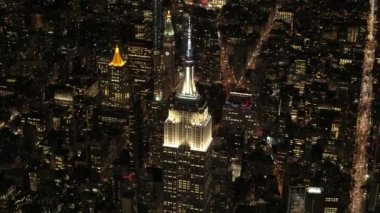 Paralel sokaklarda ikonik Empire State Binası altında yukarıda hava Heli Shot: uçan parlayan ışıkları ile büyülü yaz gecesi New York'ta aydınlandı. Midtown Manhattan'ın meşgul caddeleri araçlarda