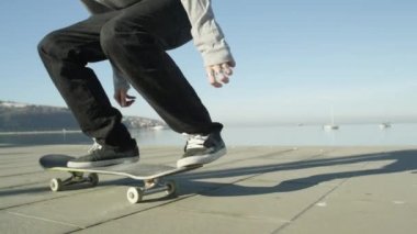 Ağır çekim, Close Up, Dof: kaykay ve 360 flip hüner okyanus boyunca güneşli yaz aylarında atlama tanınmaz kaykaycı. Kaykaycı binme kaykay Kickflip hüner atlama
