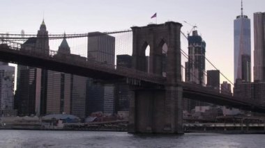Brooklyn köprüsüne doğru ikonik Downtown Manhattan siluetinin altında Doğu Nehri boyunca yakın Up, düşük görüş açısı: Gezi alacakaranlık cruise. Günbatımı kızdırma ünlü gökdelenler ve kat mülkiyeti daireler