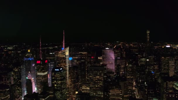ニューヨーク アメリカ合衆国 2016 夕暮れ時に高いガラス高層ビル間明るく照らされたタイムズ スクエアの撮現代的な高層ビルやマンションの輝く夜に — ストック動画