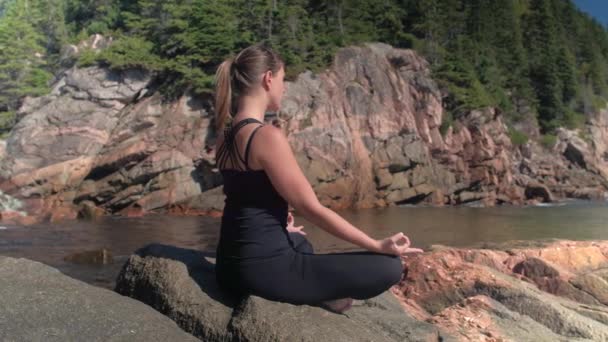Close Aantrekkelijke Jonge Vrouw Mediteren Zittend Rode Vulkanische Rotsachtige Kust — Stockvideo