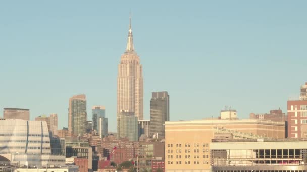 纽约市曼哈顿市中心的标志性帝国大厦 在夕阳的金色色调灿烂 纽约混凝土丛林中的当代摩天大楼 住宅大楼和公寓楼 — 图库视频影像