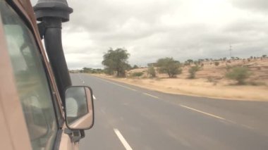 Karatu, Tanzanya - 10 Haziran 2016: Safari jeep turist Milli Parklar oyun bir sürücü için doğru ülkenin yerel yolda sürüş. Afrika kırsal ve Masai insanlara otomobilin penceresinden görüntülemek