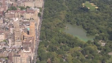 Anteni: güneşli New York'ta gür yeşil Central Park'a bakan üst Batı Yakası yukarıda uçan. Lüks kat mülkiyeti apartmanlar sarı taksileri tam meşgul avenue boyunca Central Park Manzaralı