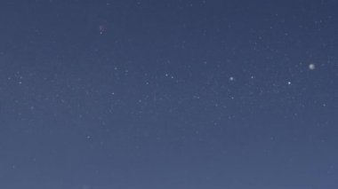 Ağır çekim Bokeh yakından: kar yağışı ve ışıltılı mavi gökyüzüne karşı nefes kesen kar taneleri. Açık bir soğuk kış gününde gökten elmas tozu olarak adlandırılan kar yağışı dondurulmuş