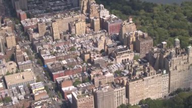 Anteni: güneşli New York'ta gür yeşil Central Park'a bakan üst Batı Yakası yukarıda uçan. Lüks kat mülkiyeti apartmanlar sarı taksileri tam meşgul avenue boyunca Central Park Manzaralı