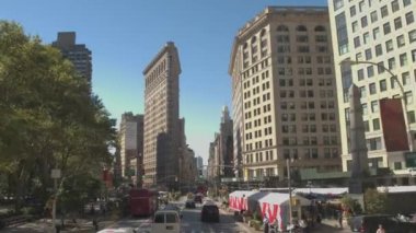 New York, Amerika Birleşik Devletleri - 23 Eylül: güneşli New York'ta Broadway'de Flatiron Binası doğru 5th avenue boyunca sürüş. Arabalar ve sarı taksileri Manhattan'ın ünlü Flatiron Binası dönüm noktası sürüş
