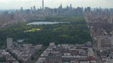 Hava: çağdaş cam gibi gökdelenler ve kat mülkiyeti apartmanlar güzel yeşil Central Park'a bakan güneşli New York şehir üzerinde uçan. Central Park ile ikonik Nyc Manhattan view
