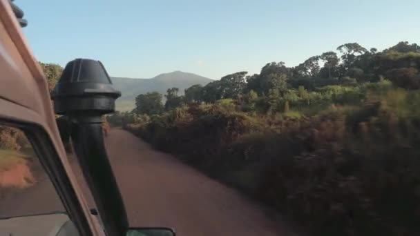 Fpv 所有地形狩猎吉普车充满游客游戏在尘土飞扬的山路上通过郁郁葱葱的绿色稀树草原丛林森林到著名的塞伦盖蒂国家公园 野生动物保护区在坦桑尼亚 — 图库视频影像