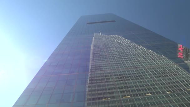 低角度のビューを閉じる 有名なニューヨーク市で見事な日当たりの良い夏の日の雲一つない青空ワン ワールド トレード センターを反映してガラスのファサードと近代的な高層ビルを魅力的なマンハッタン — ストック動画