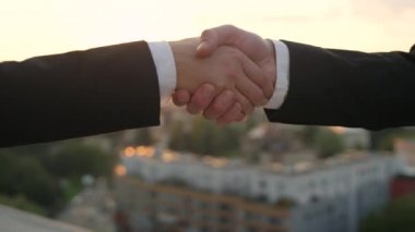 Ağır çekim Dof yakından: Tanınmayan kişi başarıyla sonuçlandırılması altın günbatımı güzel cityscape arka planda ile anlaşma ne zaman kadın iş arkadaşı ile tokalaşırken resmi siyah elbiseli