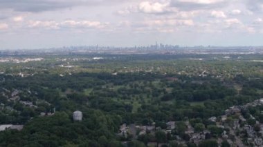 Hava kurulması Shot: ufukta yukarıda lüks emlak evler ve evler ünlü New York şehir silüeti doğru uçan. Uzun boylu gökdelenler ve kat mülkiyeti binalar ile büyük cityscape