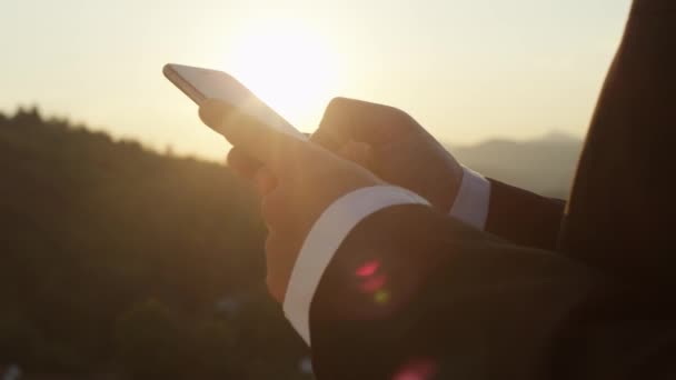 슬로우 Dof 메시지 비즈니스 검은색과 정장에 남자의 손에의 일몰에 핸드폰에 — 비디오