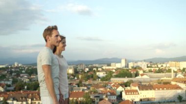 Yakın kadar ağır çekim Dof: Güzel renkli city adlı arıyorum harika manzaralı çatı kenarına çift ayakta. Mesafe içine parmak ile işaret kız evinin gösterilen erkek