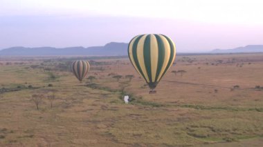 Hava: Serengeti Milli Parkı çarpıcı mesafe içine yuvarlanan sonsuz savannah ovaları yukarıda uçan Safari sıcak hava balonu. Gezmeye, Afrika yaban hayatı vahşi şafakta zevk turist
