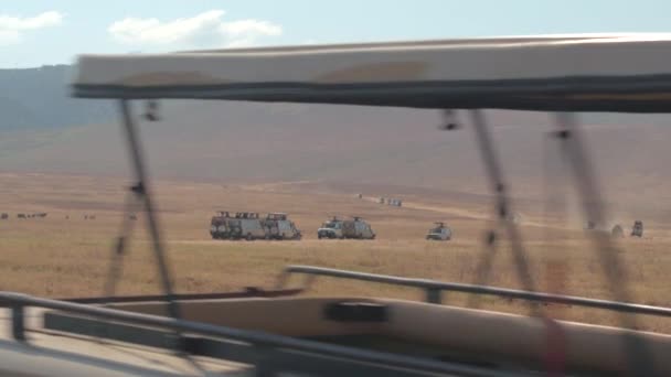 几辆野生动物园吉普车游戏 引导游客穿越迷人的干旱的非洲大草原 在恩戈罗恩戈罗保护区火山口的草原平原上觅食的野味动物 — 图库视频影像