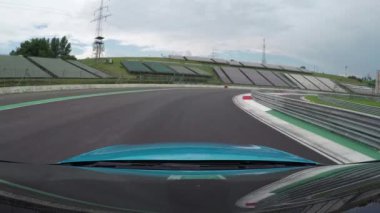 Düşük açılı görünümü kadar yakın: Yeni mavi kişisel spor araba yüzüğe çok hızlı tur sürüş ve lüks Hungaroring yarış rekabet izlemek. Beyaz yarış arabası hız yarış devre üzerinde ve yol alarak