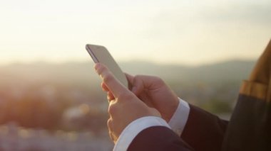 Ağır çekim, Close Up, Dof: Açık havada yazma iletileri çalışan ve iş gönderme tanınmaz işadamı detayını eğe yolu ile çatı üzerinde cep telefonu ayakta şaşırtıcı Altın ışık gündoğumu, ilgili