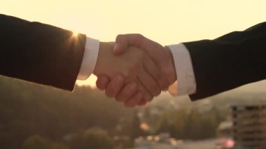 Ağır çekim Dof yakından: Tanınmayan kişi başarıyla sonuçlandırılması iş başında altın günbatımı güzel cityscape arka planda ile anlaşma ne zaman kadın Yöneticisi ile tokalaşırken resmi siyah elbiseli