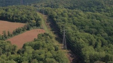 Hava: modern elektrik elektrik şebekesi, iletim sütunlar ve yüksek gerilim elektrik hatları güzel büyümüş yaprak döken dağ ormanları ile düz çizgi nazik tepenin yamacında çalıştıran yukarıda uçan