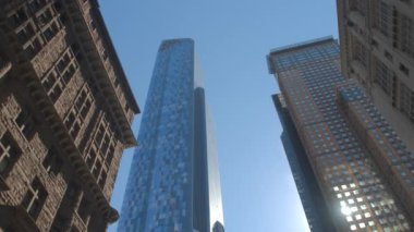 Ağır çekim yakın çekim: Modern evler, cam gibi gökdelenler, çağdaş ofis binaları, pahalı oteller ve daireler şehir merkezinde güneşli New York'ta iş mavi gökyüzünde karşı büyük konut bloğu