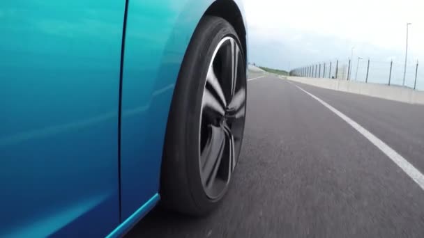 Alacsony, szög, Kilátás közelről: Új kék személyes sportkocsi vezetői kör nagyon gyorsan, és a luxus Hungaroring verseny versenyző pálya a gyűrű. A versenypálya fehér versenyautó gyorshajtás és az élen
