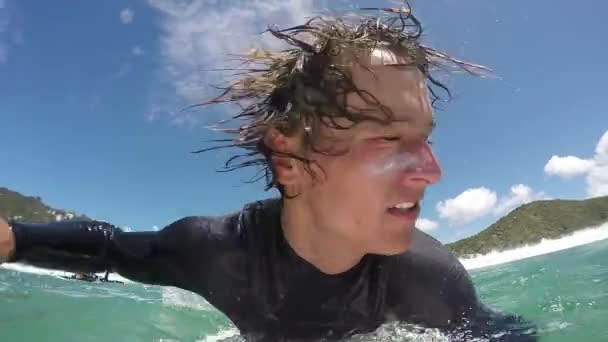 スローモーションをクローズ アップ 幸せな若いサーファー鴨波の下でダイビング ラインナップに向かってパドリングをします ニュージーランドの海でサーフィン陽気なサーファーの男 — ストック動画