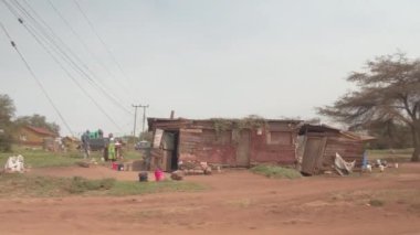 Karatu, Tanzanya - 10 Haziran 2016: Gelişmemiş üçüncü dünya Afrika gecekondu köy, geleneksel canlı renkli khanga giyim eşyası ve çökmekte, yaşayan insanlar kurulu çöken evler inşa