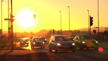 Trzin, Slovenya - 5 Ocak 2017: meşgul yoğun trafik karayolu boyunca sürüş araçlarda parlayan büyük altın güneş. Altın ışık sunset Bulvarında yol boyunca seyahat kavşak yaklaşan araba