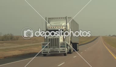 Yakın: boş birden çok şeritli eyaletler arası otoyol büyük sonsuz çayır Great Plains ile güneşli sonbahar günde yük konteyner yarı kamyon sürme. Yakıt çiftlik ve mesafe rezervuar