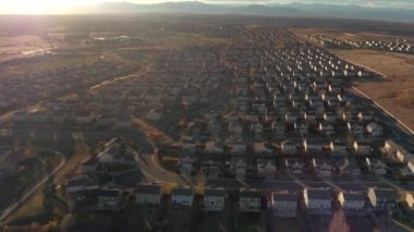 Hava: satır güzel yüksek dağlarla çevrili evlerin modern yeni banliyö köy rooftops üzerinde uçan. Colorado, Amerika pahalı suburbia kasabasında kızdırma lüks sunrise evleri