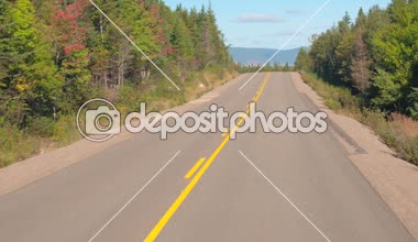POV, Close Up: rocky Dağları ve Cape Breton, Nova Scotia sahil yolunda büyük Kanadalı woodland aracılığıyla boş yolu boyunca insanların seyahat. Yolculuğa güneşli bir sonbahar gün Kanada genelinde