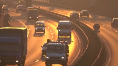 Trzin, Slovenya - 5 Ocak 2017: birden çok şeritli otoyol kalabalık commuting kişisel arabalarla meşgul ağır trafik günbatımı kızdırma, taşımacılıkta kamyon ve nakliye manyetikler yük de altın ışık akşam