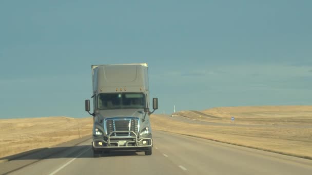 无法识别的司机转向货运集装箱半卡车在繁忙的多车道公路沿线运送货物穿过广袤的草原 — 图库视频影像