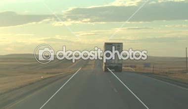 FPV yakın kadar sürüş genelinde geniş çayır Great Plains Altın ışık sabahı güneşli ve puslu doğal ülke yolu boyunca. Yetişme navlun sığır konteyner yarı kamyon canlı hayvan taşınması