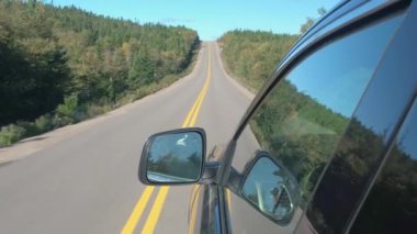 POV, Close Up: Cape Breton Highlands Milli Parkı, Nova Scotia büyük Kanadalı woodland aracılığıyla boş yolu boyunca seyahat siyah Suv araba. Yolculuğa güneşli bir sonbahar gün Kanada genelinde
