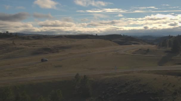 Suv 车与屋顶架驾驶沿空的高速公路运行通过阳光丘陵景观 旅行者 Roadtrip 横跨美国在州际公路通过大平原驾驶 — 图库视频影像