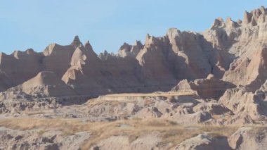 Yakın: Dik sivri kumtaşı mountaintops açık mavi gökyüzü Güney Dakota'daki Badlands ulusal parkta karşı. Great Plains otlaklar erozyona uğramış kayalık dağ oluşumları ile uzay manzara