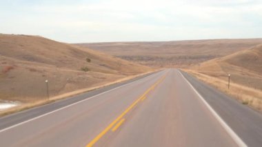 FPV: great plains otlak peyzaj çarpıcı aracılığıyla boş yol boyunca sürüş. Seyahat ve boş çayır vahşi kuru sonbaharda keşfetmek. Yolculuk boyunca Amerika Birleşik Devletleri