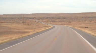 FPV: great plains otlak peyzaj çarpıcı aracılığıyla boş yol boyunca sürüş. Seyahat ve boş çayır vahşi kuru sonbaharda keşfetmek. Yolculuk boyunca Amerika Birleşik Devletleri