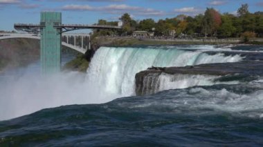 Ağır çekim: Doğal American Falls, azgın whitewater üzerinde dikey damla çökmesini hızlı. Gözlem güverte gezi görkemli şelaleler turistlere Niagara Falls güneşli sonbahar gün aradı.