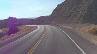 FPV: güzel Badlands yatay, kayalık kumtaşı oluşumları ile sarma boş yol boyunca sürüş. Güney Dakota'daki Badlands Çölü seyahat. Yolculuk boyunca Amerika Birleşik Devletleri.