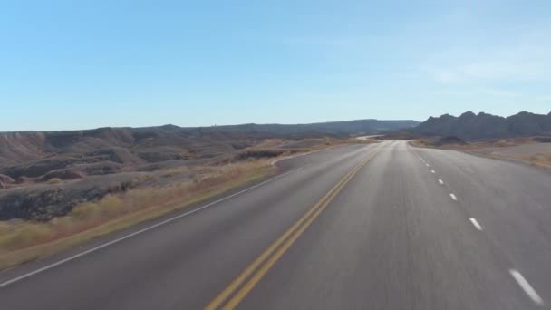 Fpv 岩の砂岩と無限のバッドランド風景を介して蛇行空の道に沿って運転しています サウスダコタ州のバッドランズ国立公園の砂漠を渡ってください アメリカ合衆国横断ロードト リップ — ストック動画