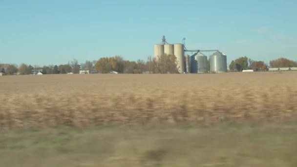 在阳光明媚的秋日 在明尼苏达州横穿马路的人们在高速公路上穿过农业乡村 经过巨大的钢铁和混凝土粮仓和玉米地 — 图库视频影像