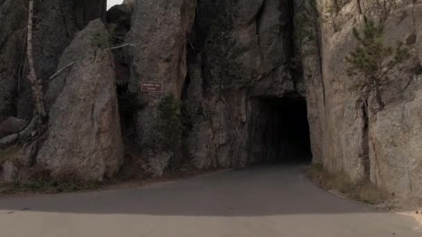 Fpv をクローズ アップ 針の目トンネルと呼ばれる岩の花崗岩壁の狭い通路を通って運転とブラック ヒルズ国立森林保護区 サウス ダコタの終了風景を見落とすと石の棚の上 — ストック動画