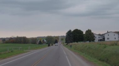 Millersburg, Amerika Birleşik Devletleri - 18th Ekim 2016: atlı arabaları tarım köy yoluyla seyahat geleneksel Amish aileler. Eski moda Amish insanlar aracılığıyla adamcağız şehirde sürüş