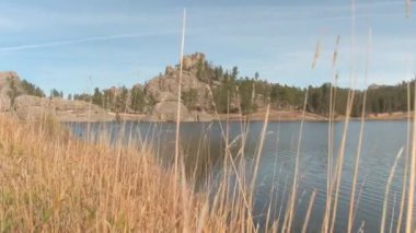 Etkileyici kaya oluşumları ve çam ağaçları Black Hill çevrili pitoresk Sylvan göl güneşli çarpıcı on Custer devlet Park gün düşer. Cam gibi su yüzeyine yansıyan kaba granit mostraları